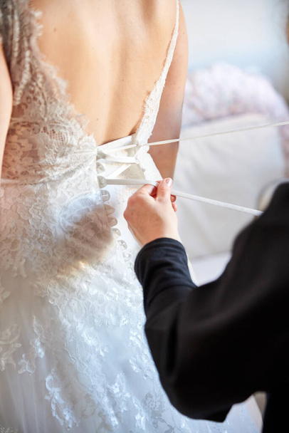 Женщина помогает невесте подготовиться к свадьбе - Фото, изображение