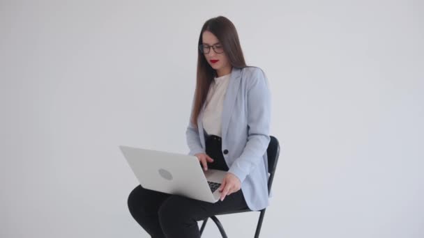 Giovane donna d'affari di successo sta lavorando su un computer portatile e guardando la fotocamera sorridente. Leader e concetto professionale - Filmati, video
