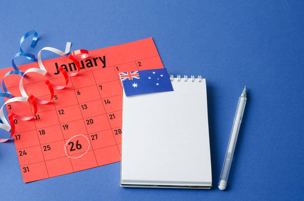 オーストラリアの日は1月26日です。青い背景に空白のノートブックシートと1月のカレンダーシート - 写真・画像