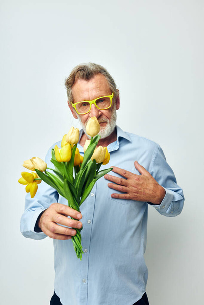 old man yellow bouquet of flowers posing isolated background - Foto, Imagen