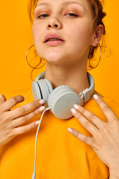 iloinen nainen irvistys kuulokkeet musiikkitekniikka keltainen tausta muuttamaton - Valokuva, kuva