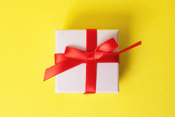 Caixa branca com um presente em um fundo amarelo fechar - Foto, Imagem