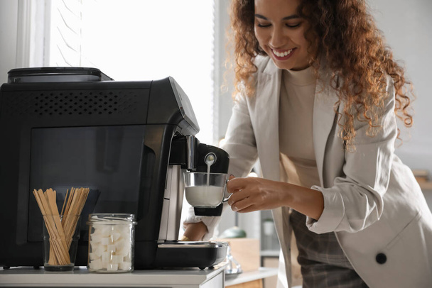 African American woman preparing fresh aromatic coffee with modern machine in office, closeup - Fotoğraf, Görsel