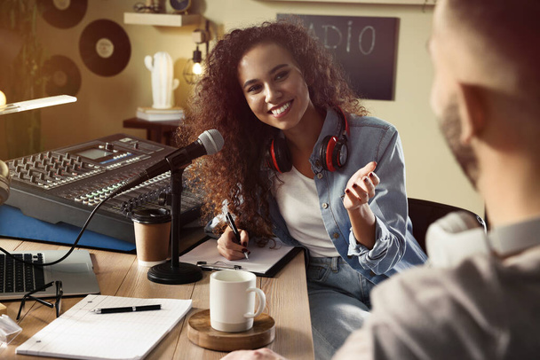 Young African American woman interviewing man in modern radio studio - Foto, Bild