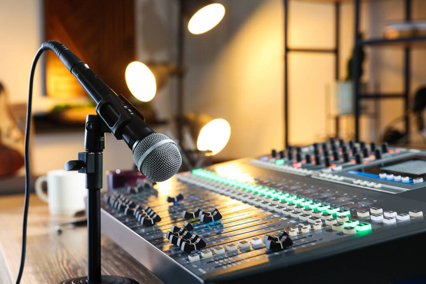 Microphone and professional mixing console on table in radio studio - Fotó, kép
