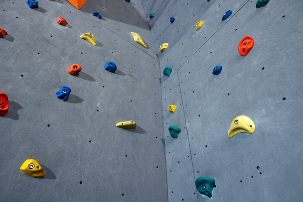 Climbing wall with holds in gym. Extreme sport - Zdjęcie, obraz