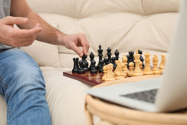 Mężczyzna grający w szachy z partnerem przez czat wideo online w domu, zbliżenie - Zdjęcie, obraz