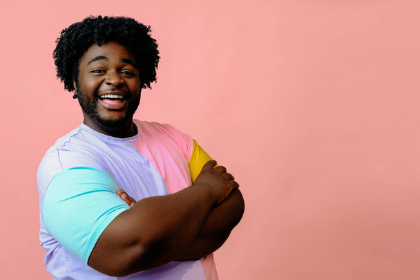 joven feliz afroamericano posando en el estudio sobre fondo rosa  - Foto, imagen