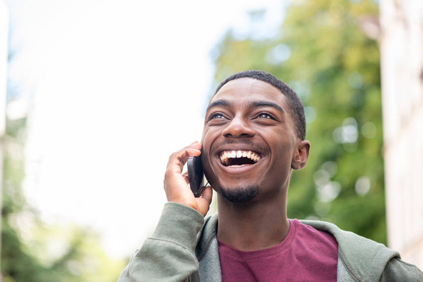 Close up portrait happy young black man talking with cellphone  - Foto, imagen