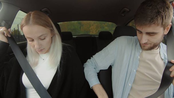 Хлопець і дівчинка керують машиною. Молода пара зачиняє ремені безпеки в машині. Люди в машині
 - Фото, зображення