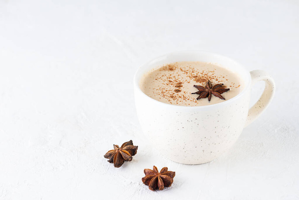 Homemade masala tea with milk, ginger root and spices in a mug on the table. Lactose free, vegan. - Fotoğraf, Görsel