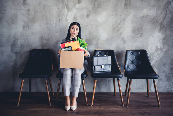 Foto in voller Größe von unzufriedenen launische Dame sitzend Stuhl halten Karton Sachen verloren Job Büro drinnen. - Foto, Bild