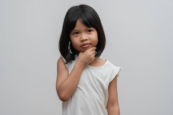 Retrato de niño asiático de 5 años y para recoger el cabello y colocar las manos en la barbilla y hacer que pensar pose sobre fondo blanco aislado, Ella es la felicidad, la luminosidad en la juventud, Concepto de educación - Foto, imagen
