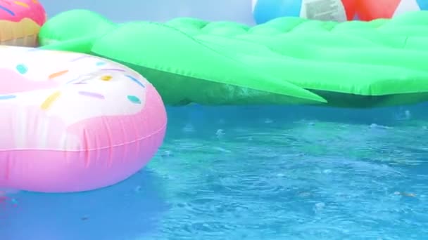 CHIUSURA: Le gocce di pioggia cadono sui giocattoli colorati che galleggiano intorno alla piscina vuota. - Filmati, video