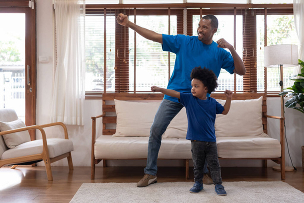 Happy African American Father and Afro boy playing at home together, Black family having fun, Power of Superhero, Single Dad, Father's day concept - Photo, image