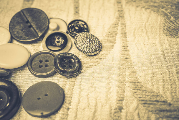 Different buttons on a background made of fabric - Foto, imagen