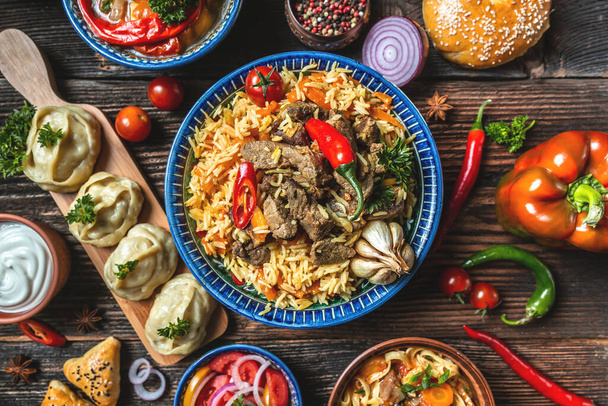 Concepto gastronómico uzbeko y de Asia Central. Surtido de comida uzbeka pilaf samsa lagman manti shurpa concepto de restaurante uzbeko comida uzbeka. Fondo de receta de alimentos - Foto, imagen