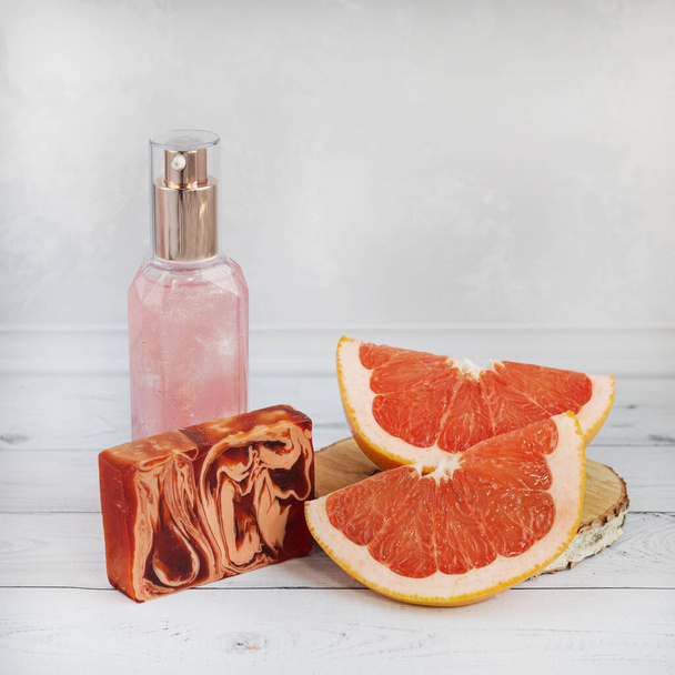 Grapefruit pieces, pink shower gel and natural soap. Natural cosmetics concept - Foto, Imagem