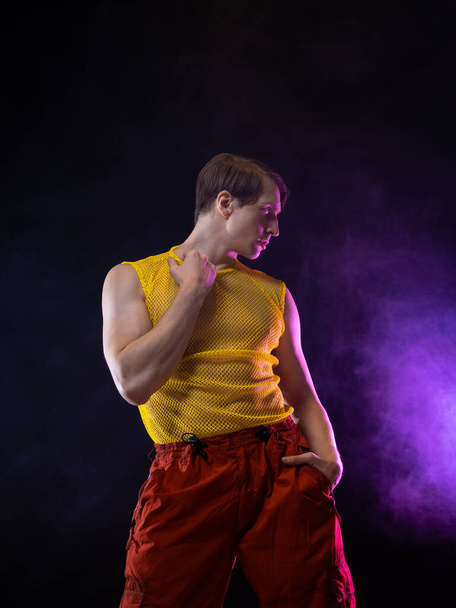 a young muscular man in a bright outfit poses in a pretentious pose, style - 写真・画像