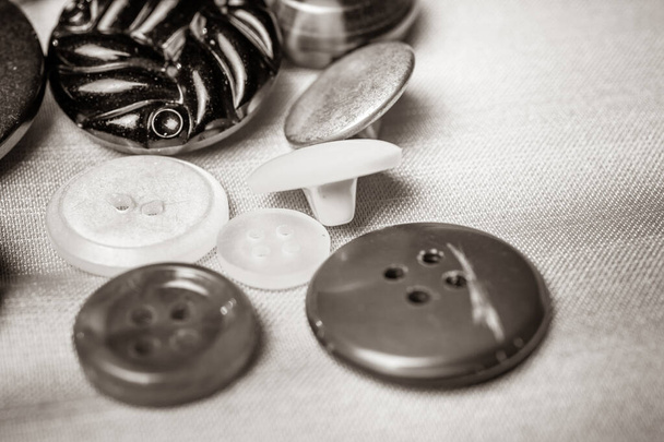 Kumaştan yapılmış bir arkaplanda farklı düğmeler - Fotoğraf, Görsel