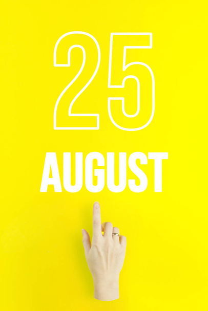 August 25th. Day 25 of month, Calendar date.Hand finger pointing at a calendar date on yellow background.Summer month, day of the year concept - Foto, afbeelding