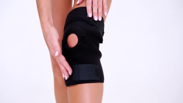 Knee Support Brace on leg isolated on white background. Orthopedic Anatomic Orthosis. Braces for knee fixation, injuries and pain. Orthotics. Foot orthosis. Knee Joint Bandage Sleeve. Elastic Sports - Footage, Video