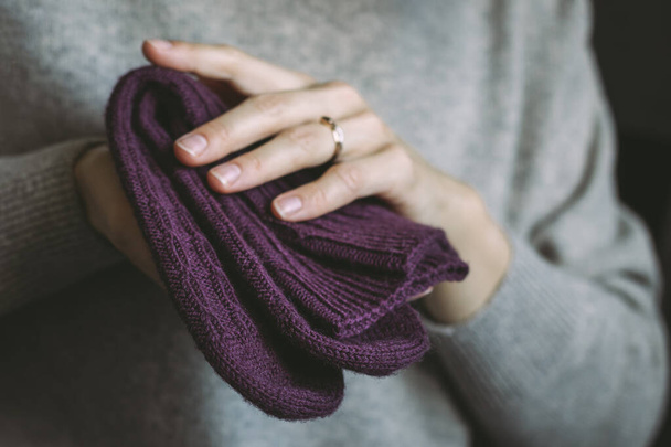 Woman with hand knitted socks on a dark background. Concept for handmade and hygge slow life.  - Zdjęcie, obraz