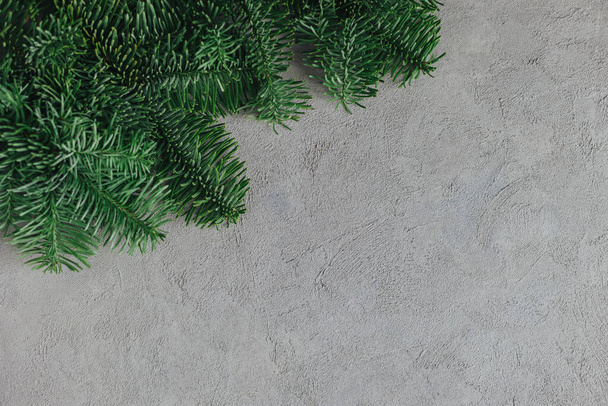 Spruce branches on a grey background. Holiday eco-friendly concept.  Flat lay. Place for text. - Foto, afbeelding