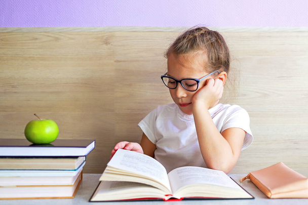 Schoolgirl girl reads books after school to know a lot - Fotoğraf, Görsel