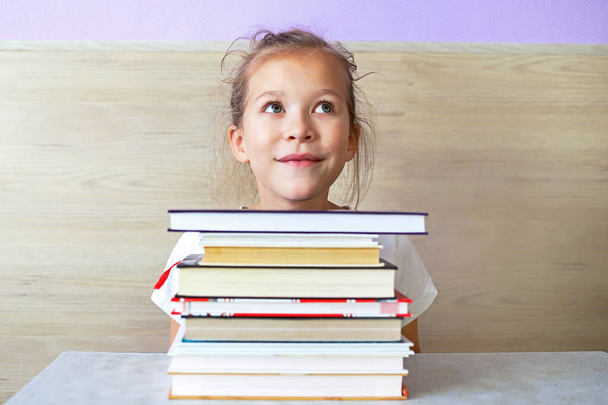 Schoolgirl girl reads books after school to know a lot - Φωτογραφία, εικόνα