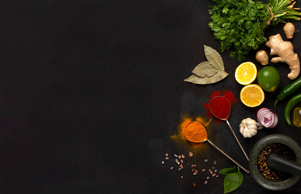 Concepto hierbas frescas jengibre limón, lima, pimentón, curry, mortero de especias, vista superior, sobre una mesa oscura, horizontal, sin personas,. Foto de alta calidad - Foto, imagen