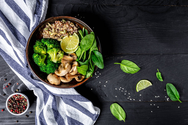 Veganer Salat aus grünem Gemüse mit Spinat, Pilzen und Brokkoli und Quinoa. Gesundes vegetarisches Essen. Ansicht von oben. - Foto, Bild