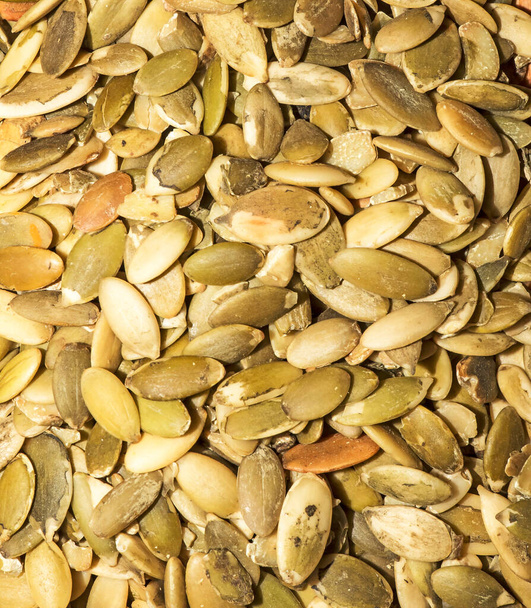 Close-up background texture of green roasted pumpkin seeds. Peeled pumpkin seeds background. - Foto, Imagem