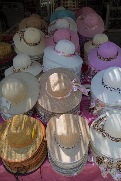 太陽から多くの帽子。異なる色の太陽からの女性のデザイナーの帽子。夏のビーチ帽子、女性のビーチ帽子のデザイン. - 写真・画像