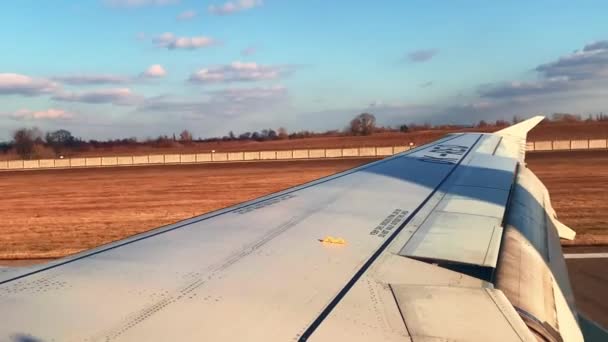 Wing with flaps raised of airplane landing on runway - Felvétel, videó