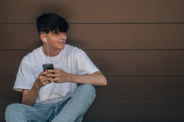 teini-ikäinen poika matkapuhelimen ja rullalauta - Valokuva, kuva