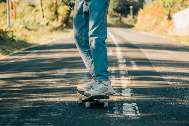 voeten op skateboard skaten op de weg - Foto, afbeelding