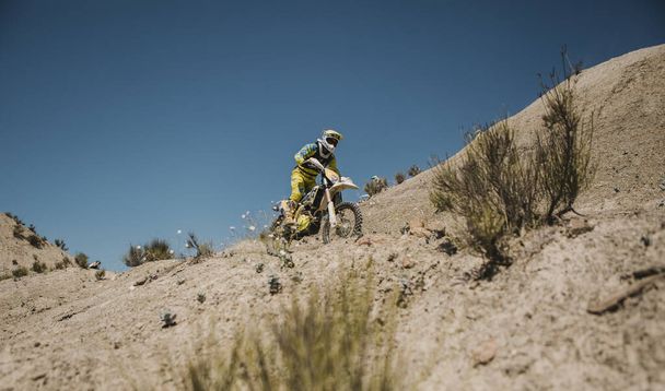 Almeria, Spain - May 5th 2021: Motocross rider riding downhill in Tabernas desert during Dunlop Xperience showroom and test in Almeria, Spain. - Foto, Imagem