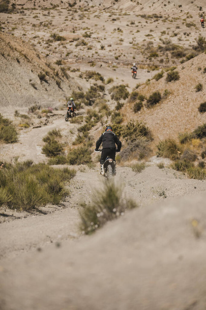 Almeria, Spain - May 5th 2021: Motocross riders riding downhill in Tabernas desert during Dunlop Xperience showroom and test in Almeria, Spain. - Foto, imagen