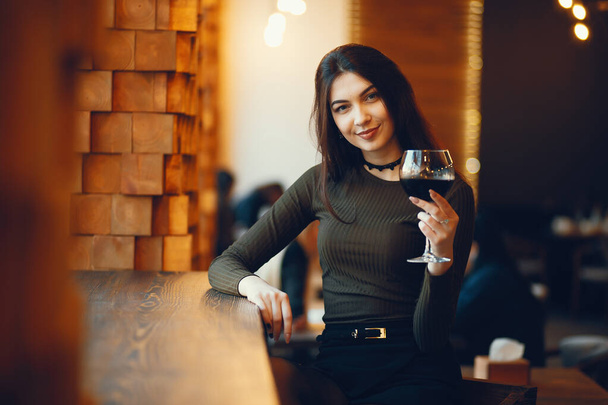 Beautiful girl holding a glass of vine - 写真・画像