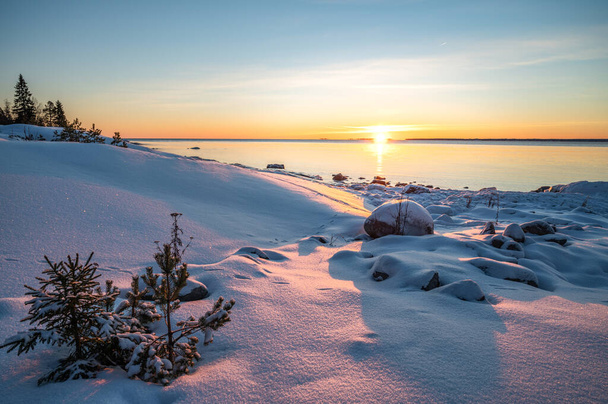 Panoramic sunset through the horizon. Winter wonderland scenery in scenic golden evening light at sunset with clouds and long shadow. tranquil nature copy space background. - Foto, imagen