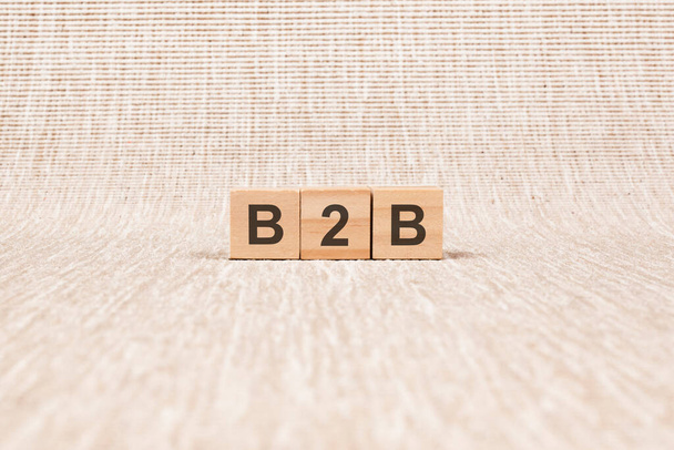 B2B word written on wood blocks. text on broun backgrond for your desing, concept. B2B - short for Business To Business - Foto, Imagen