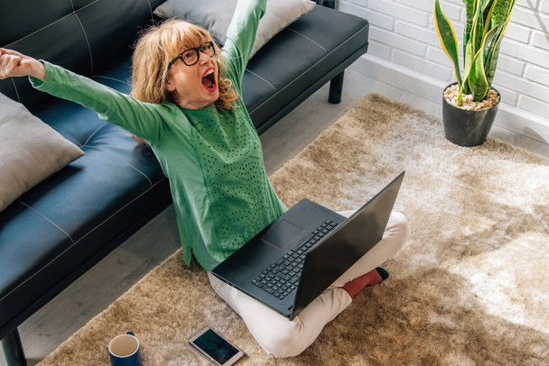 женщина дома с компьютером кричит от радости и энтузиазма с успехом - Фото, изображение