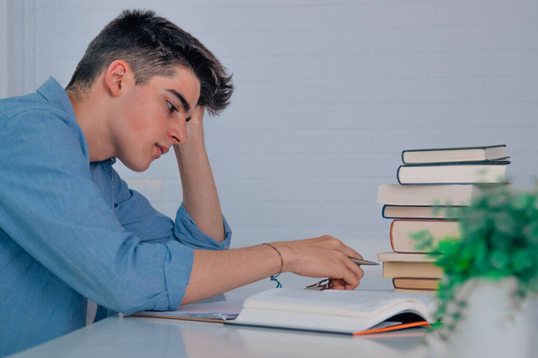 студент-підліток за столом з книгами втомленими або обтяженими стресом
 - Фото, зображення