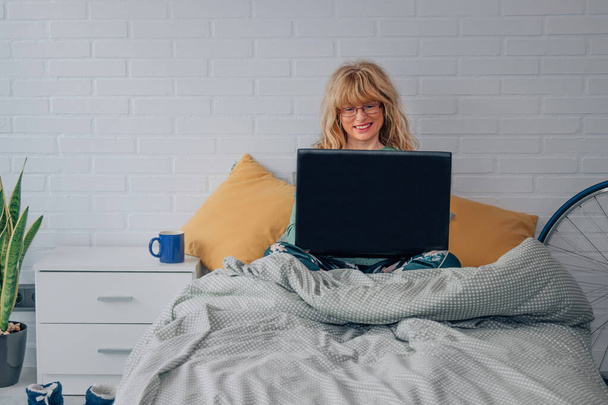 woman with computer at home in bed or bedroom - Photo, Image