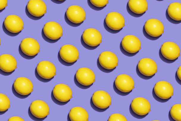 Fruit lemon in checkered pattern on violet background. Violet and yellow colors background from fruity lemon. Demonstrating very peri, color of 2022 year. - Photo, image