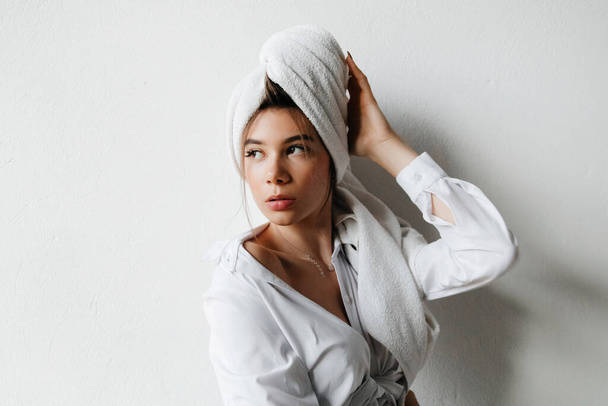 Um banho num hotel. Menina bonito em uma camisa branca toalha fresca na cabeça depois de um chuveiro - Foto, Imagem