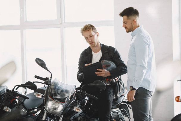 Handsome man choosing a motorcycle to buy - Fotoğraf, Görsel