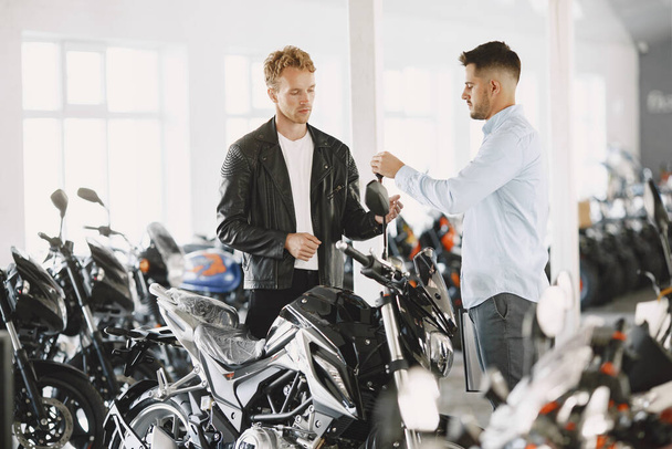 Handsome man choosing a motorcycle to buy - Foto, Bild