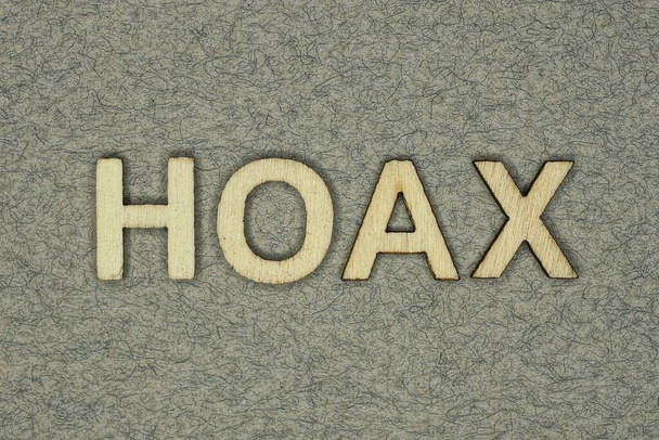 text on word hoax from wooden letters on a gray background - Foto, Imagem